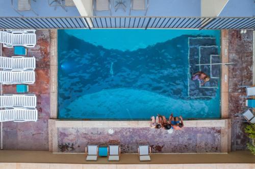 einen Pool mit Schwimmer in einem Pool in der Unterkunft Ohia Waikiki Studio Suites in Honolulu