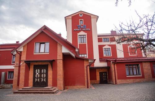 un edificio rosso e bianco con un cartello sopra di T&S Apart-Hotel a Černivci