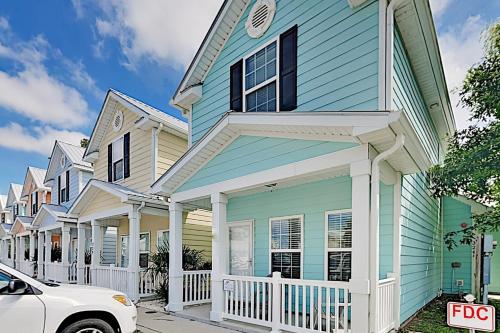 una casa azul y blanca con un coche aparcado delante en Snorkel Way, en Myrtle Beach