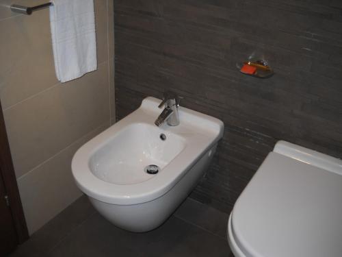 uma casa de banho com um lavatório branco e um WC. em Hotel Tiber em Fiumicino