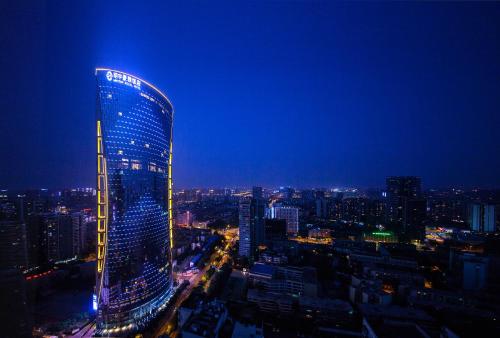 un edificio illuminato in una città di notte di Minyoun Chengdu Dongda Hotel a Chengdu