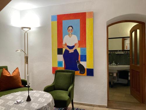 a living room with a painting of a woman on the wall at CALLM aka Zum goldenen Löwen - zu Nacht bei der Destillerie in Kallmünz