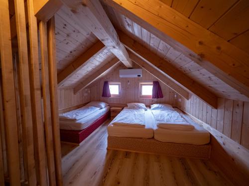 2 Betten in einem Zimmer im hölzernen Dachgeschoss in der Unterkunft Chalet Sejalec in Lesce