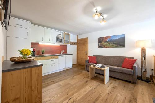 a living room with a couch and a kitchen at Oberglarzhof App Zirbel in Villnoss