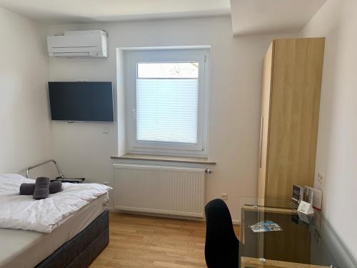 um quarto com uma cama, uma janela e uma mesa de vidro em Hotel Prinz Carl - Apartments mit Klimaanlage em Neckarsulm