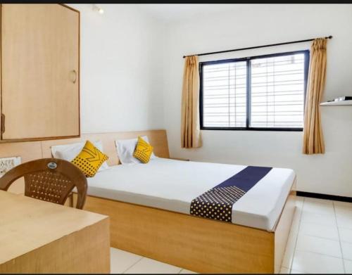 a bedroom with a large bed and a window at Hotel Rahi in Nashik