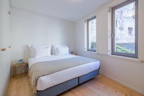 1 dormitorio con 1 cama grande y 2 ventanas en YOUROPO - Taipas, en Oporto