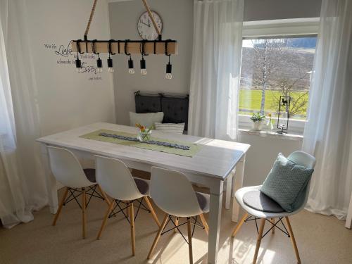 mesa de comedor blanca con sillas blancas y ventana en Ferienhaus Hopfental, en Kelheim