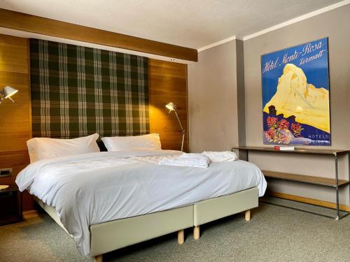 a bedroom with a large bed with a poster on the wall at Les Neiges D'Antan in Breuil-Cervinia