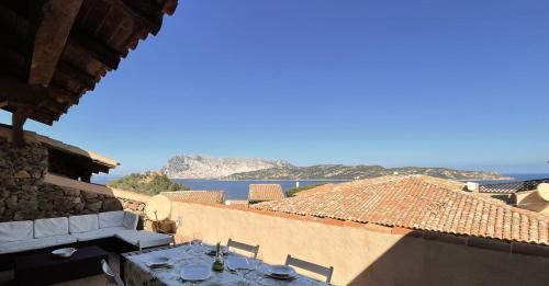 een tafel op een balkon met uitzicht op de oceaan bij SAN TEODORO PUNTA EST TRILOCALE VISTA MARE in Capo Coda Cavallo