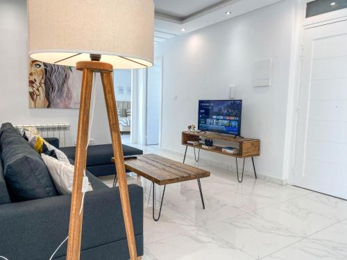 a lamp in a living room with a couch and a tv at Cosy Apartment in La Marsa - 2 bed 1 Bath in La Marsa