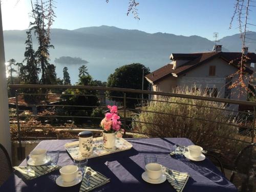 a table with a blue table cloth and flowers on a balcony at Emma in Verbania