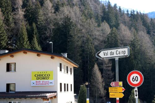 un edificio con letreros de la calle frente a una montaña en Hotel Sfazù, en Poschiavo