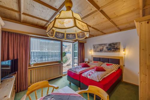 - une chambre avec un lit et un lustre dans l'établissement Apartments Olympiastraße, à Seefeld in Tirol