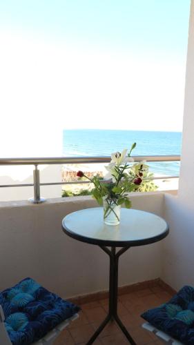 un jarrón de flores en una mesa frente a una ventana en DESiGN UNQUE appartement, en Sousse