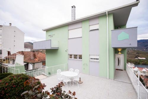 a building with a table and chairs on a balcony at Green House - Douro in Peso da Régua