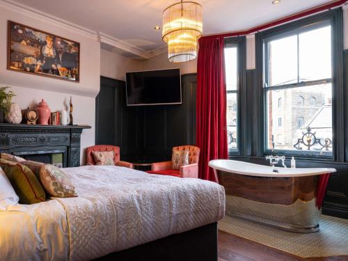 een slaapkamer met een bed, een bad en een raam bij Spread Eagle in Londen