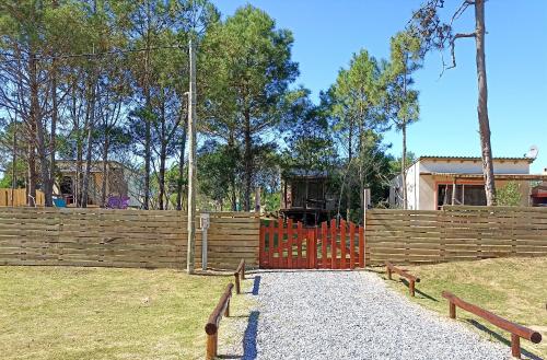 una cerca con una puerta de madera en un parque en AMORES DEL DIABLO, en Punta del Diablo