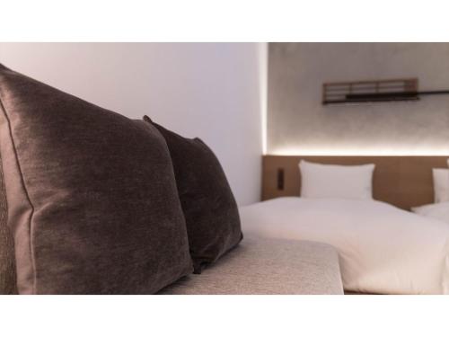 una camera con letto e divano con cuscini di nol kyoto sanjo - Vacation STAY 97692v a Kyoto