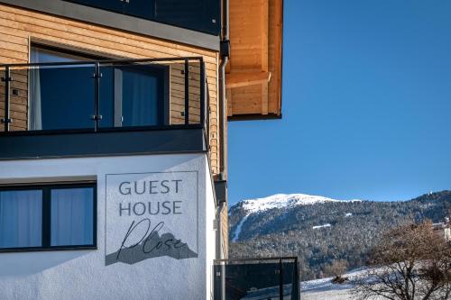 un panneau de la maison d'hôtes sur le côté d'un bâtiment dans l'établissement Guesthouse Plose, à Bressanone