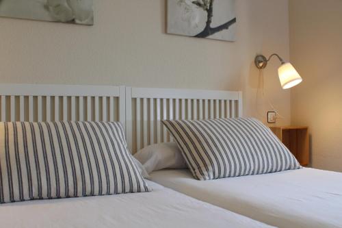 a bedroom with a bed with two pillows on it at Apartamentos Los Hidalgos in Santillana del Mar