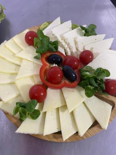 une plaque remplie de fromage, de tomates et de poivrons dans l'établissement Pensiunea LUKA Slanic Moldova, à Slănic-Moldova