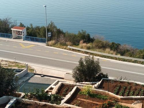 an empty road next to the water with a building at Apartmani NIKA in Dubrovnik