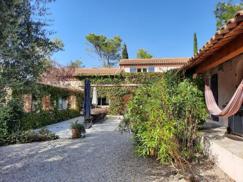 Saint-Paul-en-ForêtにあるLa Salamandre en Provenceのパティオ付きの庭園のある家