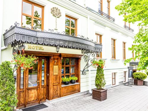 ein Geschäft vor einem Gebäude mit einer Holztür in der Unterkunft Hotel Pod Złotą Różą in Kielce