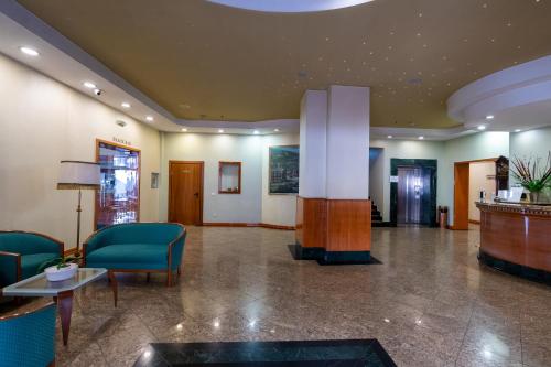 un hall d'un hôpital avec des chaises et une table dans l'établissement Best Western Hotel Turist - Superior, à Skopje