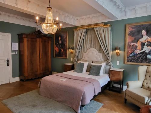 - une chambre avec un lit, une chaise et un lustre dans l'établissement Boutique Hotel Huys van Leyden, à Leyde