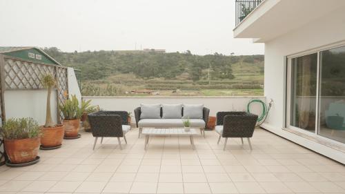 a patio with a couch and chairs on a balcony at Terraço dos Rabujas in Nazaré