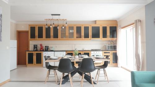 a kitchen with a dining room table and chairs at Terraço dos Rabujas in Nazaré