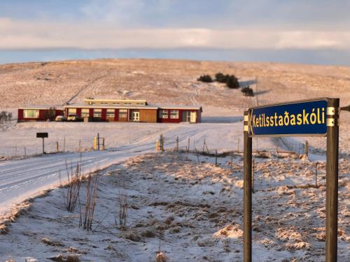 um sinal de rua em frente a um edifício na neve em Volcano Hotel em Vík