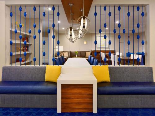 a dining room with a table and blue chairs at Sonesta ES Suites Chicago - Schaumburg in Schaumburg