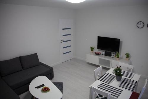 een woonkamer met een bank en een tafel bij Apartament Wrocław Borowska in Wrocław