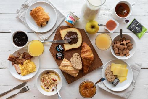 a table topped with plates of breakfast foods and drinks at B&B HOTEL Thionville Centre Gare Porte du Luxembourg A31 in Thionville