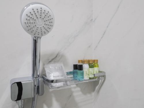 a shower head and a shelf with cosmetics on it at Hotel Anastasia in Sibiu