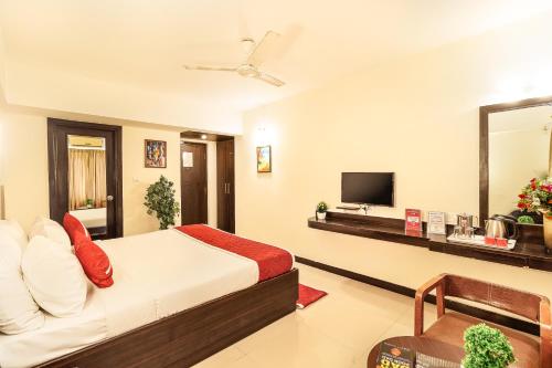 a hotel room with a bed and a television at Octave Himalaya Monarch in Bangalore