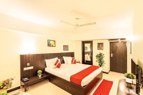 a bedroom with a bed with red pillows at Octave Himalaya Monarch in Bangalore