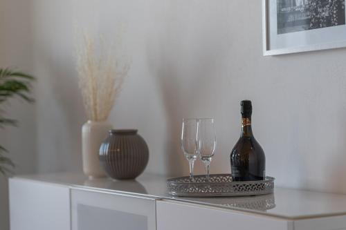 a bottle of wine and two glasses on a cabinet at Casa Raffaello in San Miniato