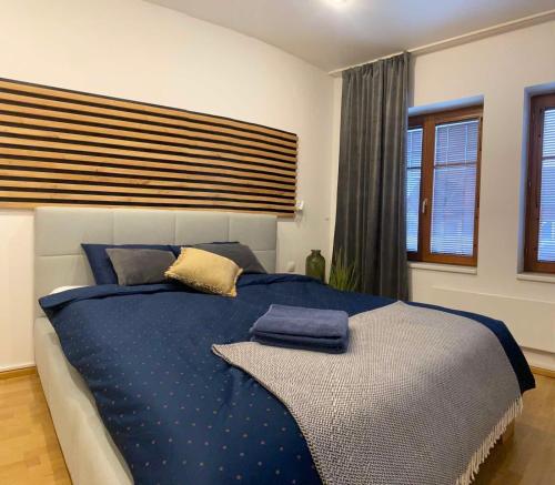 ein Schlafzimmer mit einem blauen Bett mit Kissen darauf in der Unterkunft Apartmán Lara in Komárno