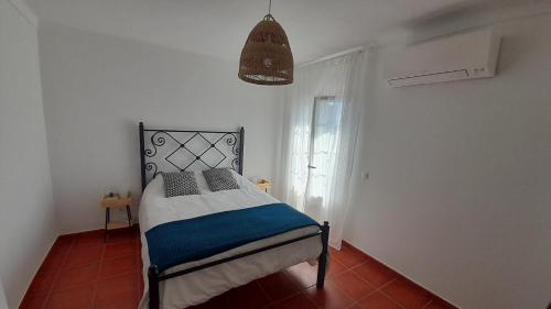 um quarto com uma cama num quarto com uma janela em Porta Reguengos - Apartamento moderno Alentejo central em Reguengos de Monsaraz