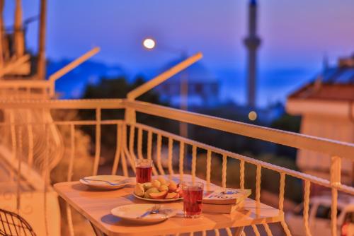 une table avec une assiette de nourriture sur un balcon dans l'établissement Ayshe Apart, à Kaş