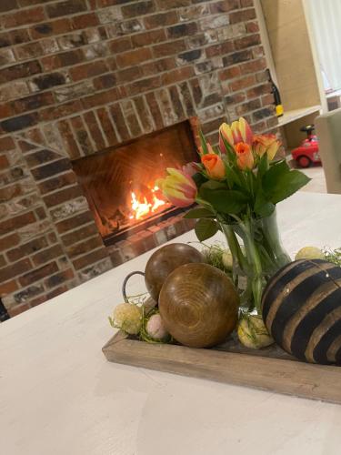 een tafel met een vaas met bloemen en een open haard bij Divá Kačica Restaurant & Pansion in Komárno