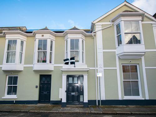 a yellow house with black doors and windows at Baker Chambers in Camborne