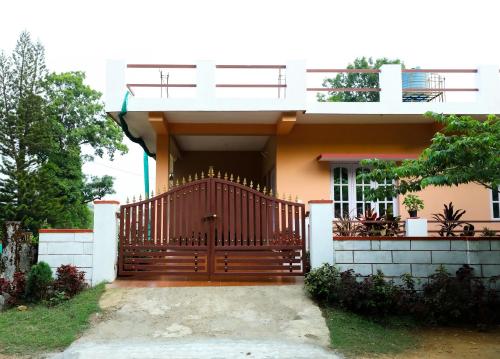 une maison avec une porte en bois devant elle dans l'établissement Srishti Homestay, à Madikeri