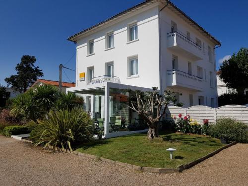 een wit gebouw met een tuin ervoor bij The Originals Access, Hôtel Corinna, Royan in Royan