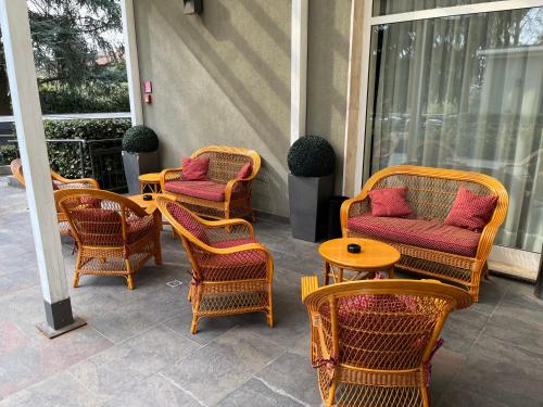 un grupo de sillas y mesas de mimbre en un patio en Bis Hotel Varese, en Varese