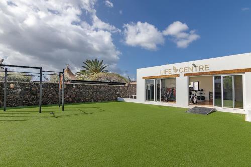 a building with a yard with a basketball hoop at Casas Heddy, Well-being Resort in Puerto del Carmen